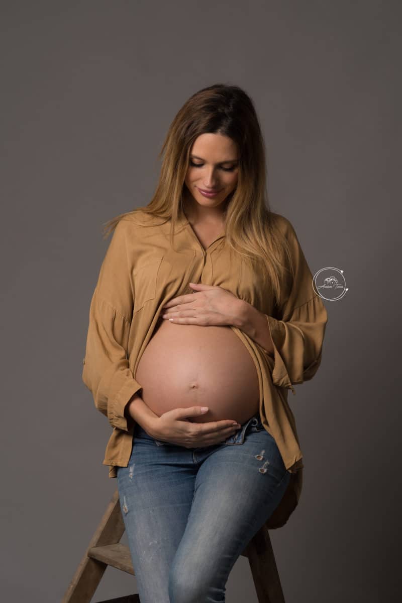 Photo d'une femme enceinte assise sur un tabouret