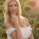 Photo d'une femme dans un champ de tournesol au coucher de soleil