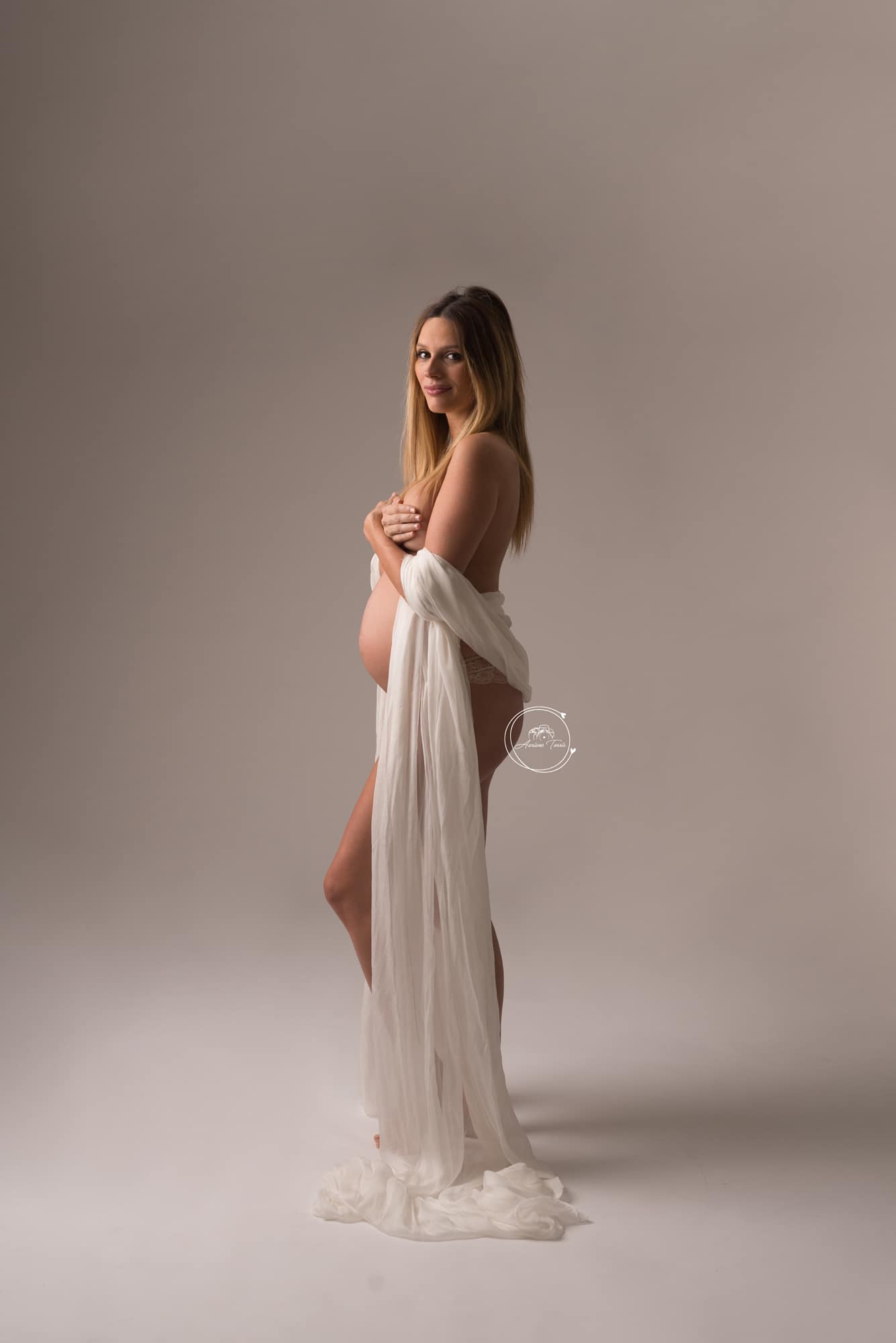 Photo d'une femme enceinte avec un voilage blanc