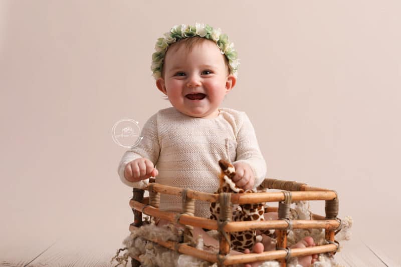 Photo d'une petite fille de 9 mois qui rigole pendant une séance photo