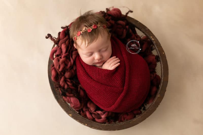 Photo d'un nouveau-né de quelques jours dans un décor aux couleurs de Noël