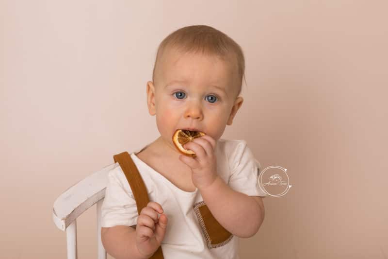Photo d'un bébé qui mange une rondelle d'orange