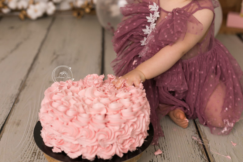Photo des mains de Louisa dans son gâteau pour sa séance photo smash the cake