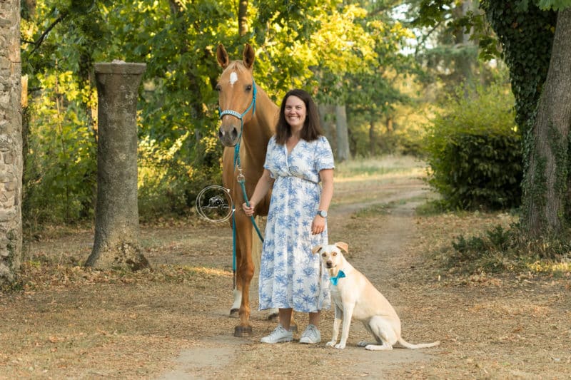 Photo d'une cavalière avec sa jument et sa chienne