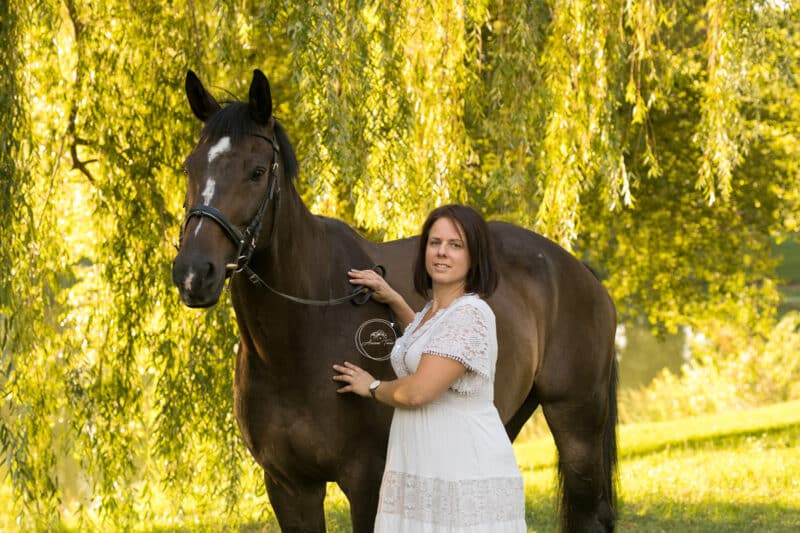 Photo d'une cavalière avec son cheval dans un parc